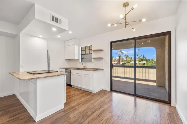 a large kitchen with kitchen island a large counter space a sink appliances and cabinets