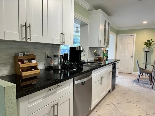 a kitchen with granite countertop a sink a stove and cabinets
