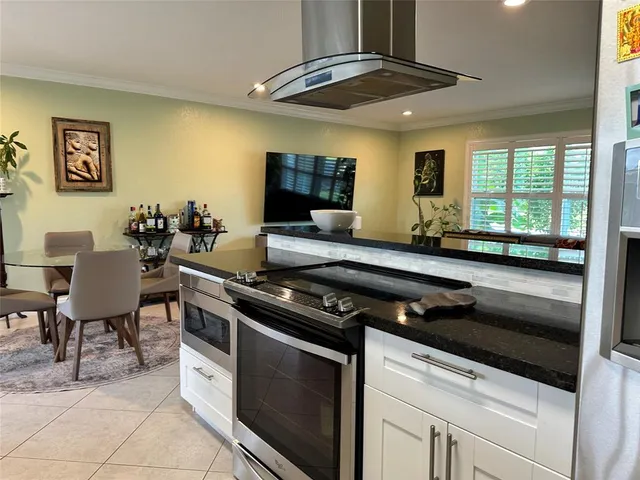 a kitchen with stainless steel appliances granite countertop a stove a sink and a microwave