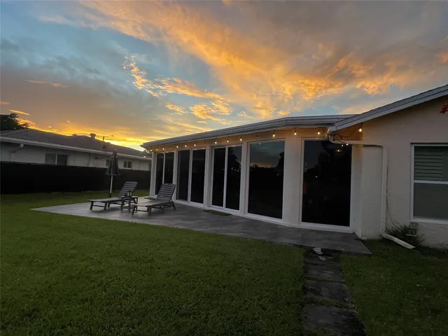 a view of a backyard with table and chairs and wooden fence