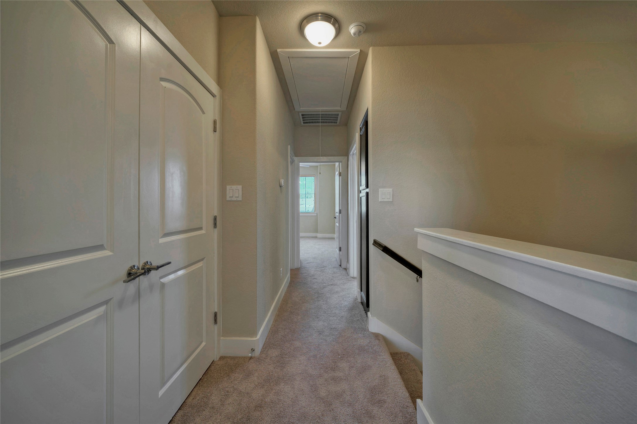 508 High Tech Drive, Unit B Georgetown, TX 78626 - Photo 13 of 24 A well-maintained upstairs hallway connects rooms, featuring plush carpeting and a discreet attic access panel.