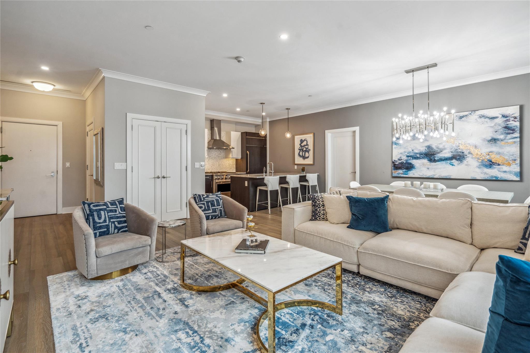 100 Garvies Point Road, Unit 1126 Glen Cove, NY 11542 - Photo 13 of 40 Living room with hardwood / wood-style flooring, crown molding, and a notable chandelier