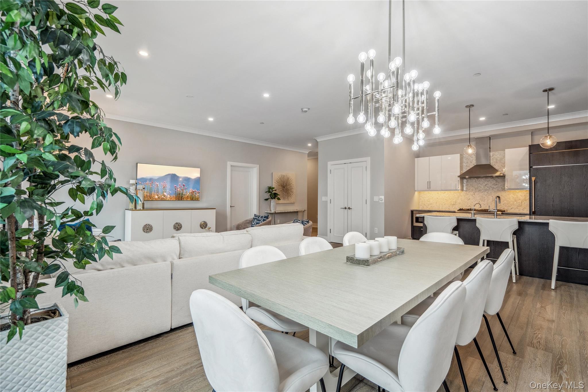 100 Garvies Point Road, Unit 1126 Glen Cove, NY 11542 - Photo 15 of 40 Dining space featuring light hardwood / wood-style floors, an inviting chandelier, and crown molding