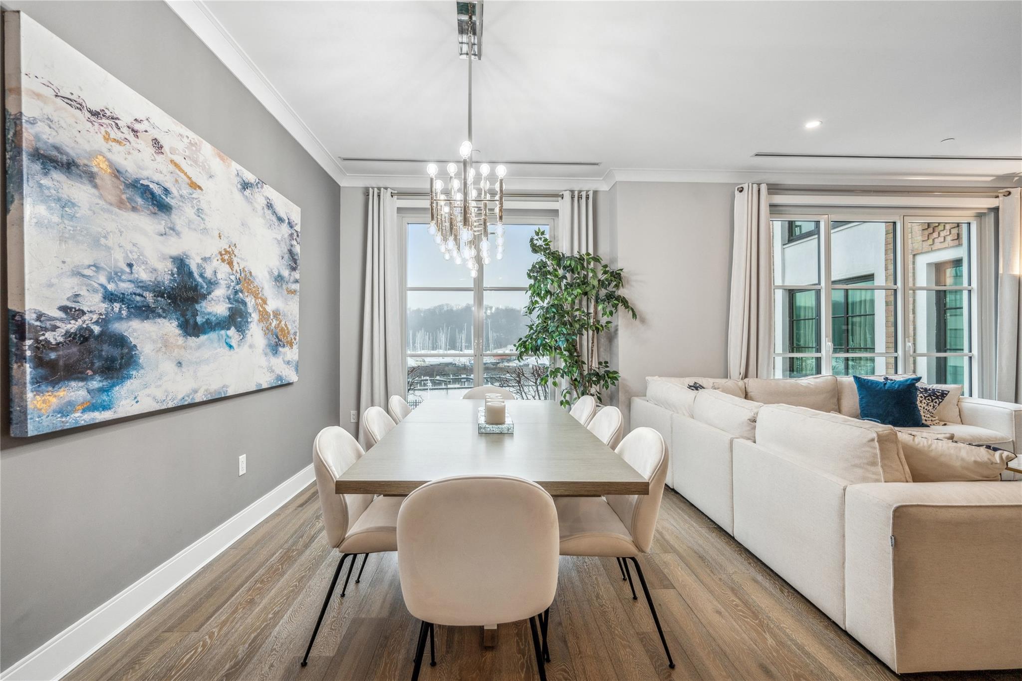 100 Garvies Point Road, Unit 1126 Glen Cove, NY 11542 - Photo 18 of 40 Dining room with a notable chandelier, light hardwood / wood-style floors, crown molding, and a wealth of natural light