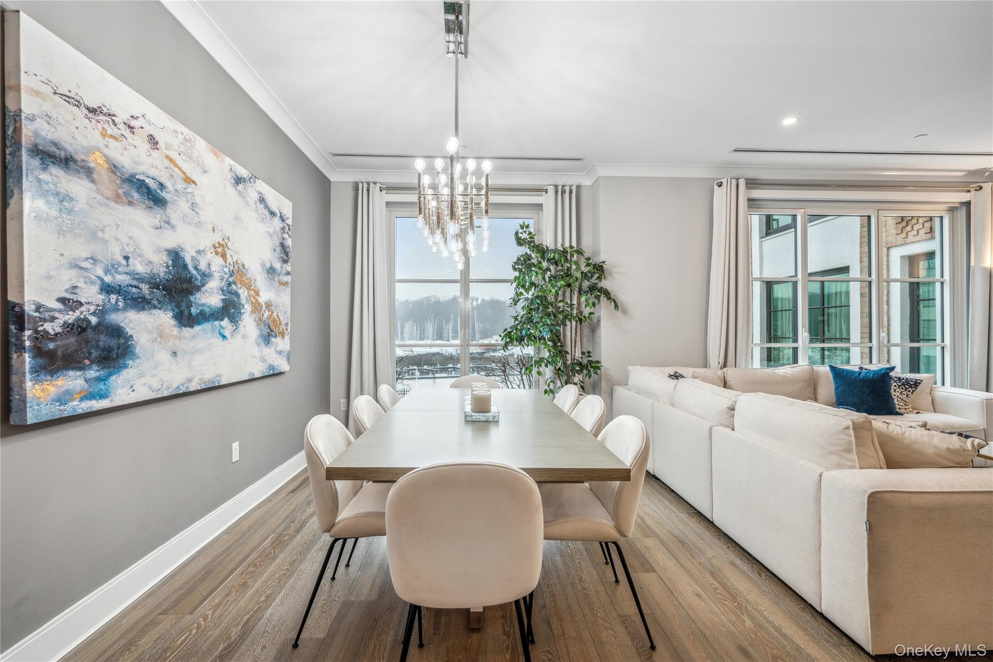 100 Garvies Point Road, Unit 1126 Glen Cove, NY 11542 - Photo 18 of 40 Dining room with a notable chandelier, light hardwood / wood-style floors, crown molding, and a wealth of natural light