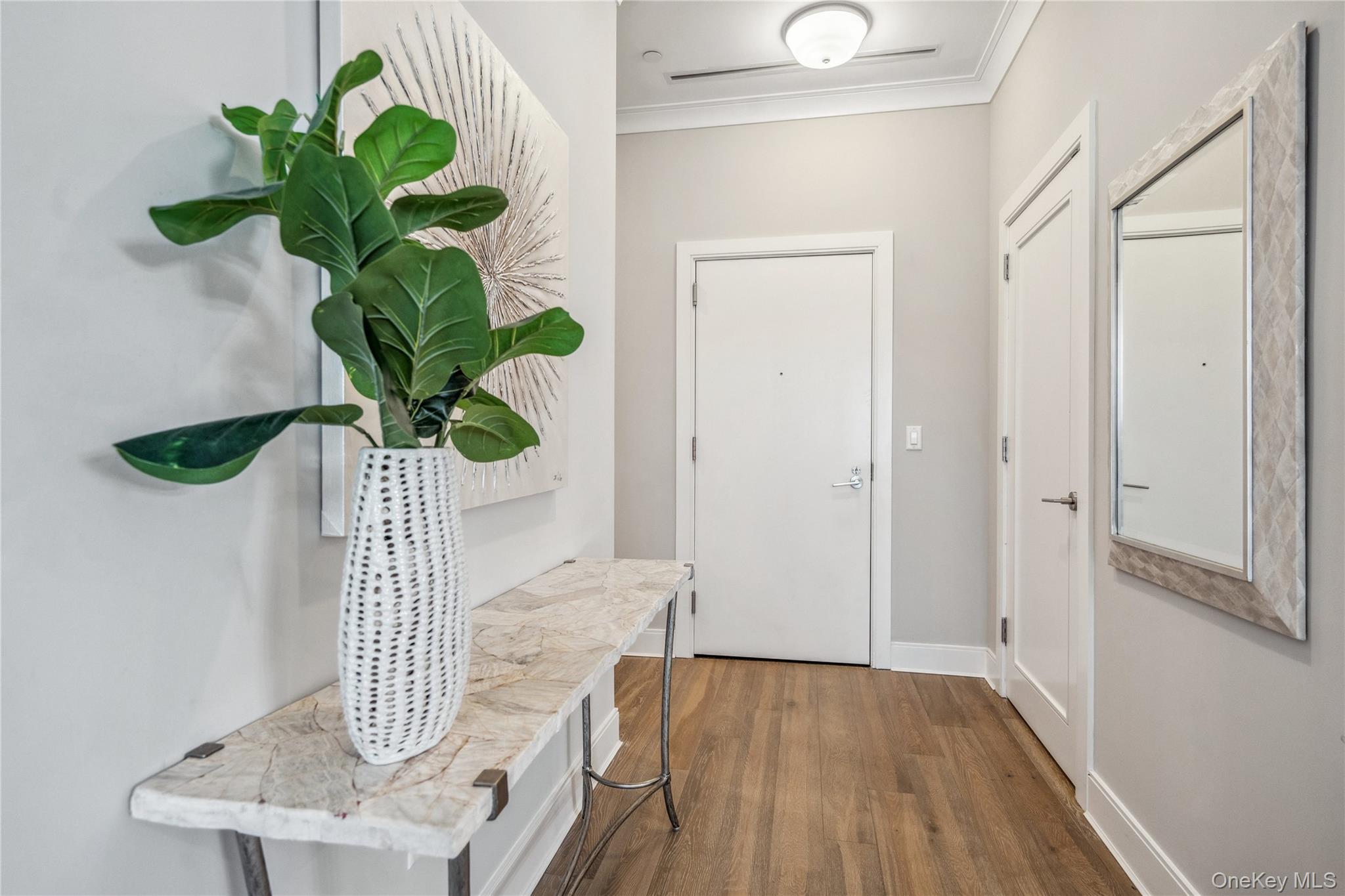 100 Garvies Point Road, Unit 1126 Glen Cove, NY 11542 - Photo 2 of 40 Doorway with crown molding and dark wood-type flooring