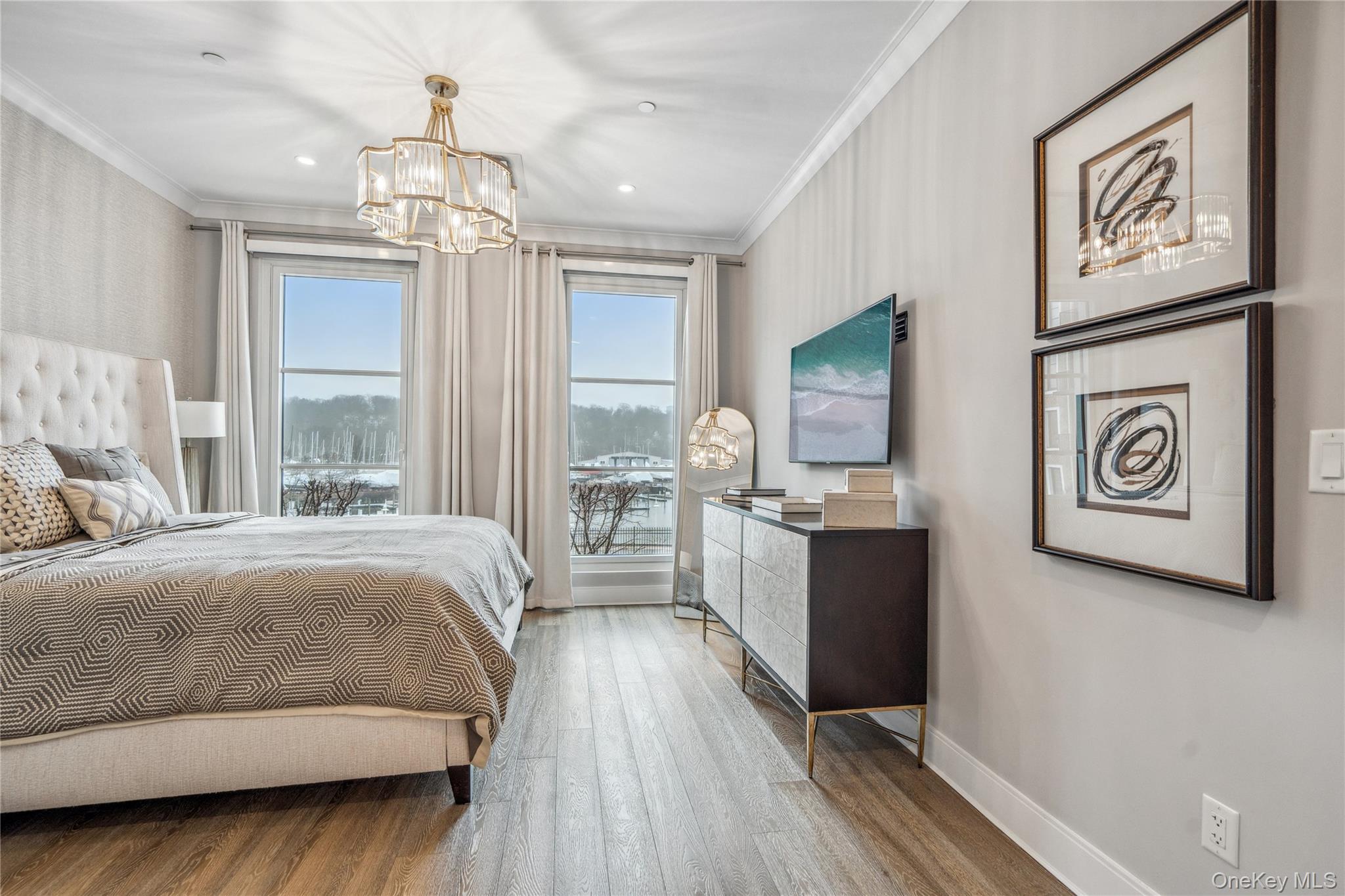 100 Garvies Point Road, Unit 1126 Glen Cove, NY 11542 - Photo 28 of 40 Bedroom featuring hardwood / wood-style floors, ornamental molding, and an inviting chandelier