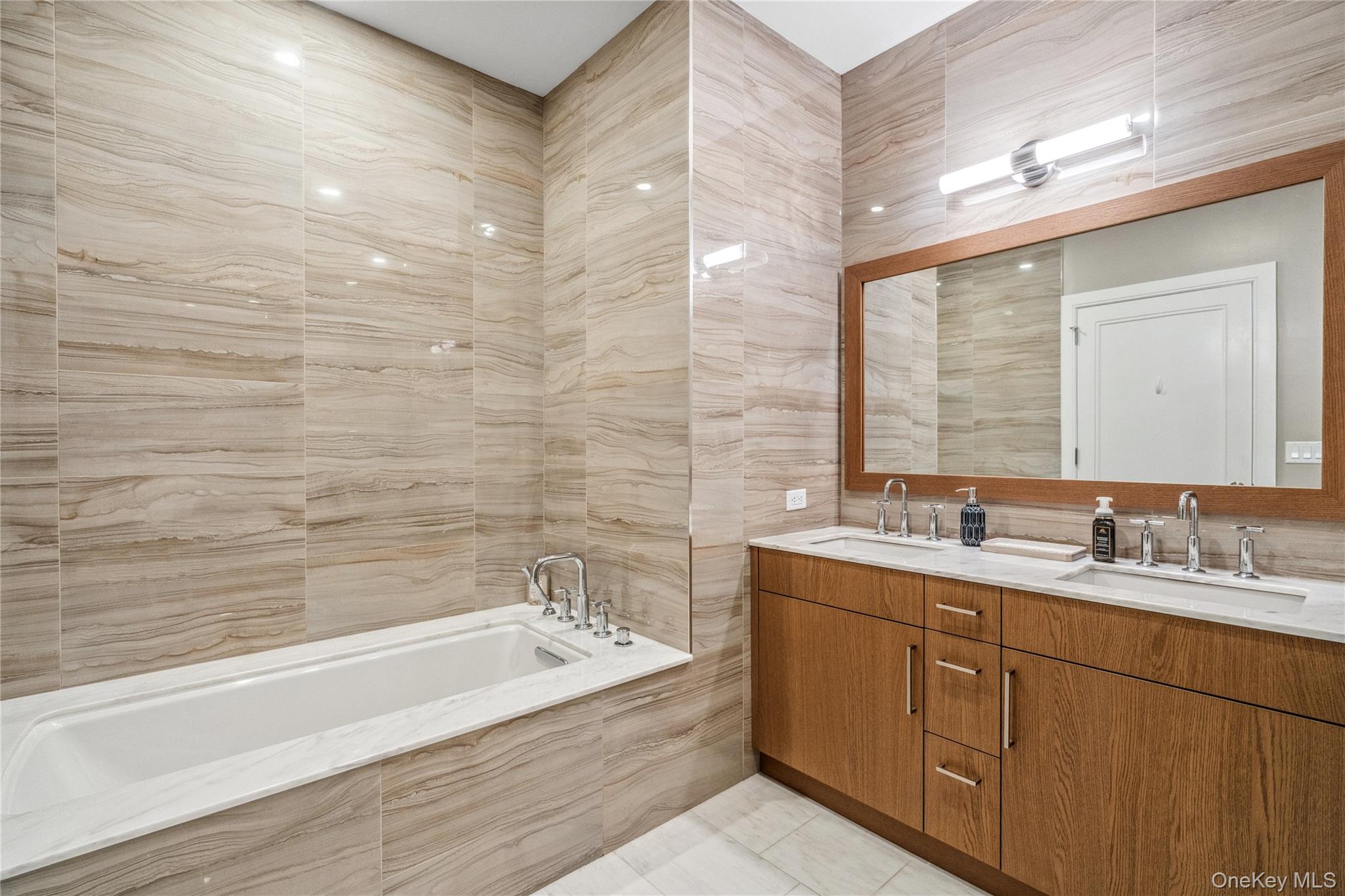 100 Garvies Point Road, Unit 1126 Glen Cove, NY 11542 - Photo 31 of 40 Bathroom featuring vanity, a relaxing tiled tub, tile patterned floors, and tile walls