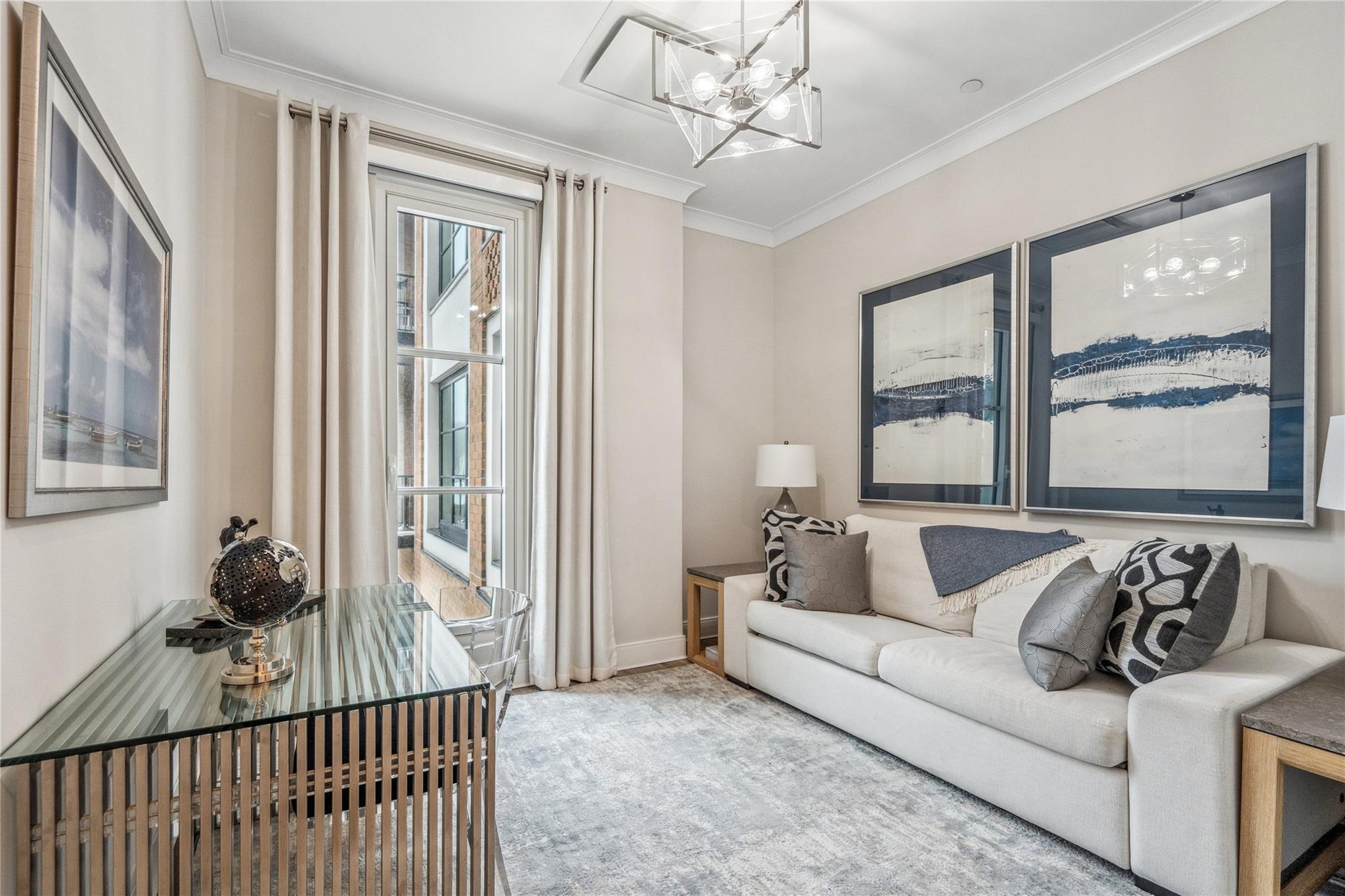 100 Garvies Point Road, Unit 1126 Glen Cove, NY 11542 - Photo 9 of 40 Living room with a chandelier, a wealth of natural light, and ornamental molding