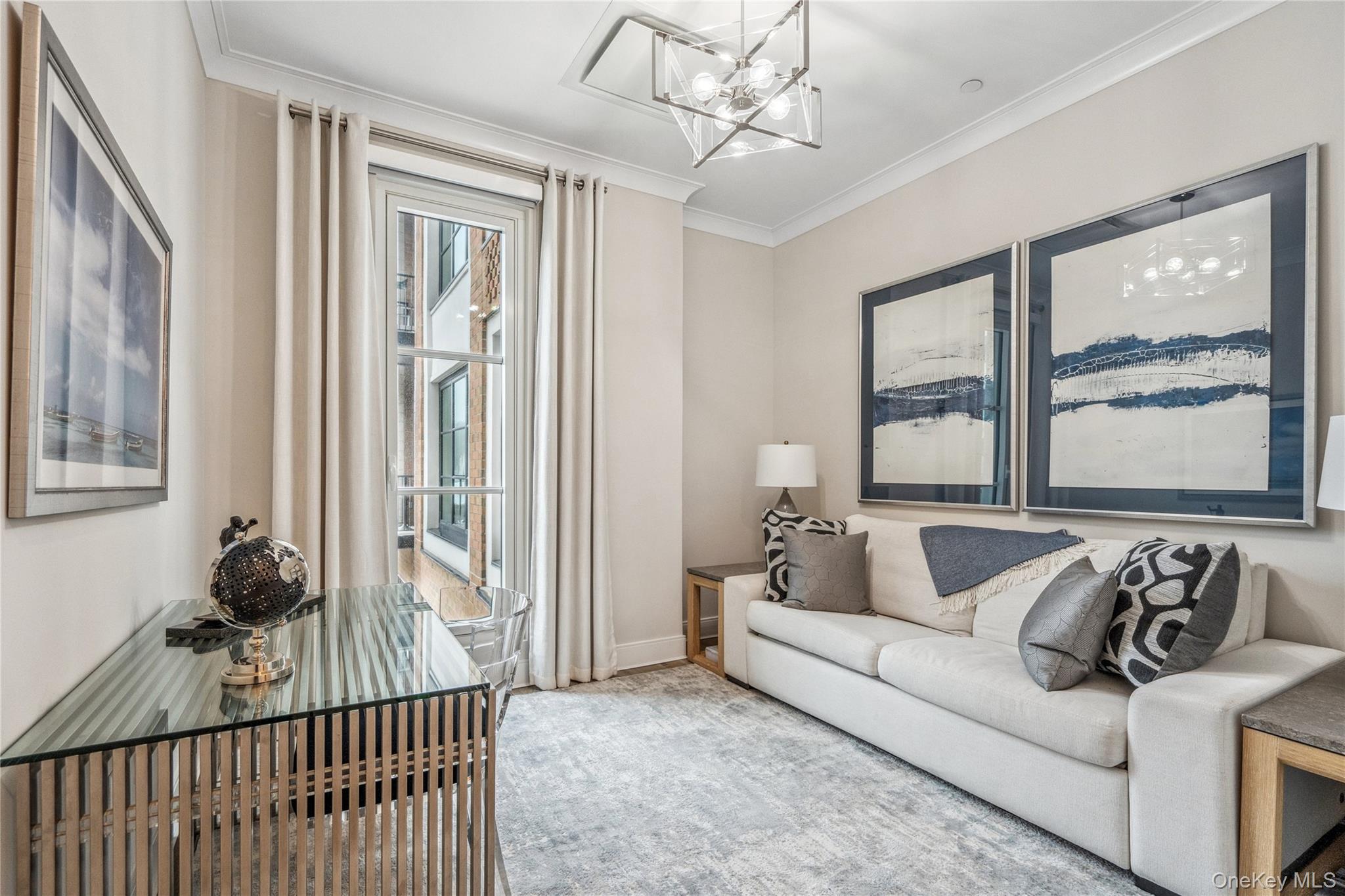 100 Garvies Point Road, Unit 1126 Glen Cove, NY 11542 - Photo 9 of 40 Living room with a chandelier, a wealth of natural light, and ornamental molding