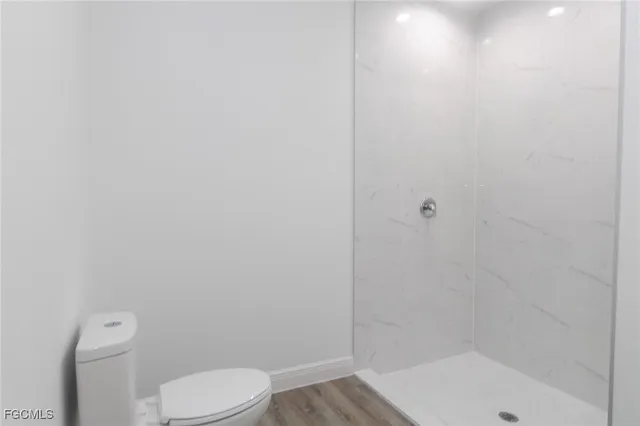 a white toilet sitting next to a bath tub and a shower