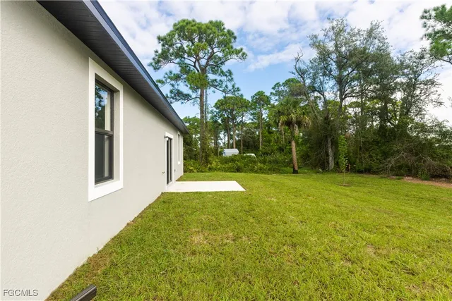 a view of backyard of house with green space