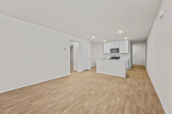 a view of kitchen with kitchen island wooden floor center island and stainless steel appliances