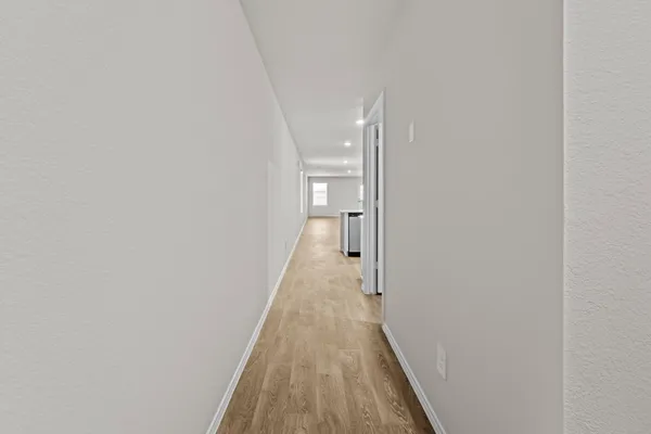 a view of a hallway with wooden floor