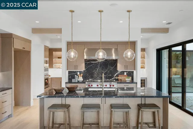a open kitchen with stainless steel appliances granite countertop a stove and a wooden floors