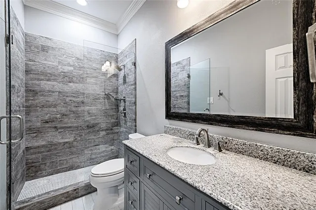 a bathroom with a granite countertop sink toilet and shower
