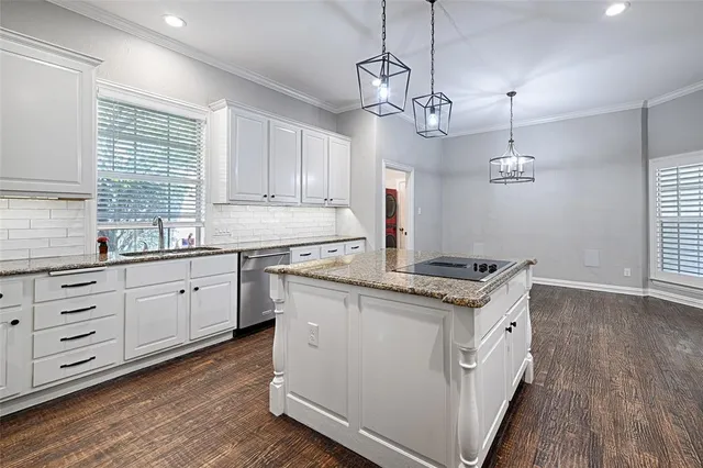 a open kitchen with granite countertop a stove a sink dishwasher a refrigerator and white cabinets with wooden floor