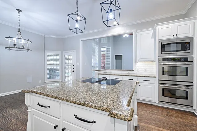 a kitchen with stainless steel appliances granite countertop a stove and a wooden floors