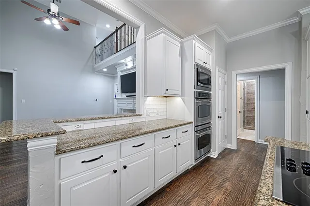 a kitchen with granite countertop a cabinets and wooden floor