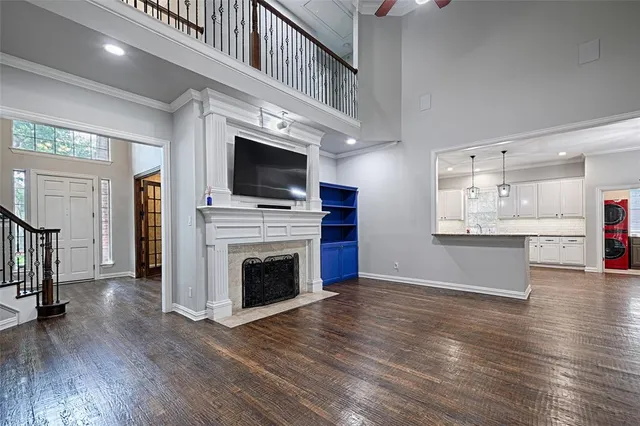 a view of living room kitchen with stainless steel appliances wooden floor and large window