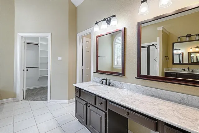 a spacious bathroom with a granite countertop sink and a mirror