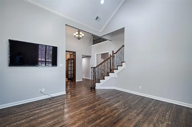 a view of a livingroom with wooden floor and staircase