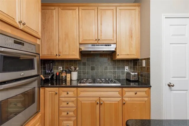 a kitchen with stainless steel appliances granite countertop a stove and a microwave