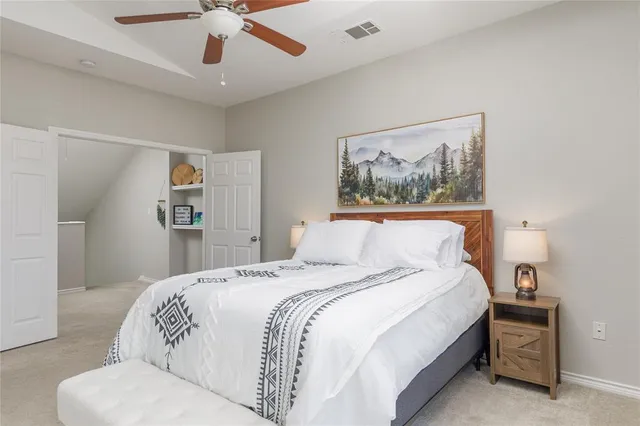a bedroom with a large bed and a chandelier