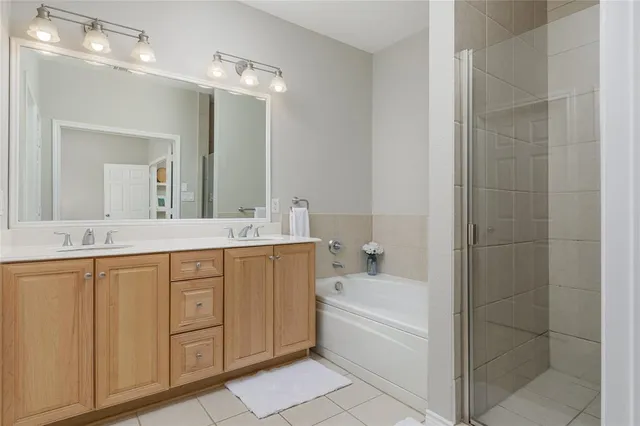 a bathroom with a bathtub a double vanity sink and mirror