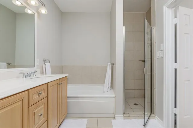 a bathroom with a granite countertop sink a mirror and bathtub