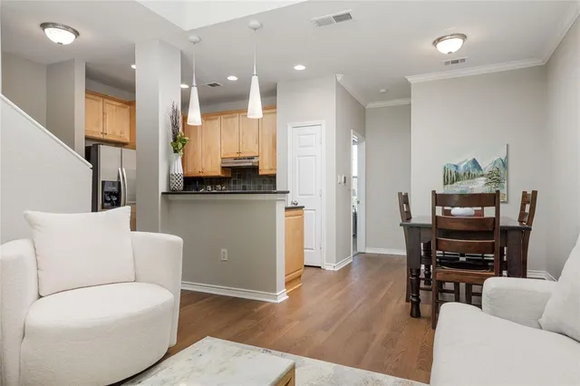 a living room with furniture and a dining table with kitchen view