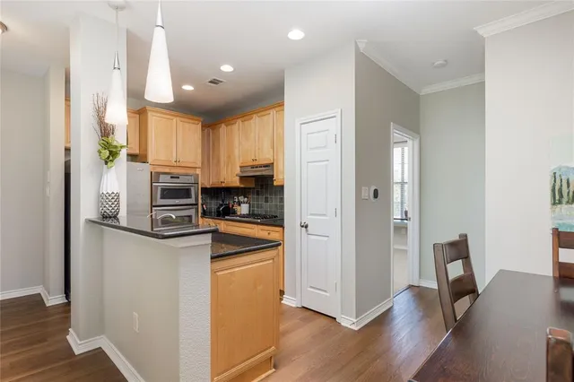 a kitchen with stainless steel appliances granite countertop a refrigerator and a stove top oven