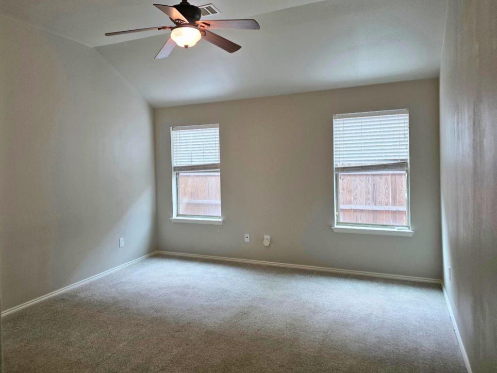 6320 Spring Ranch Drive Fort Worth, TX 76179 - Photo 7 of 24 Carpeted interior space featuring neutral wall tones, two windows with blinds, a ceiling fan with integrated lighting, and crown molding