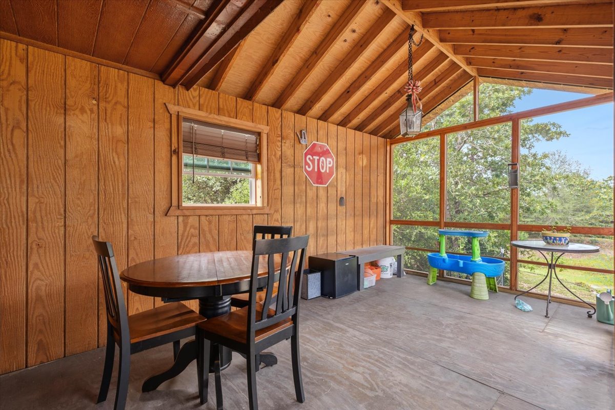 1705 Makinson Road West Point, TX 78963 - Photo 23 of 40 A rustic screened porch with wood paneling and exposed beams offers a peaceful retreat.