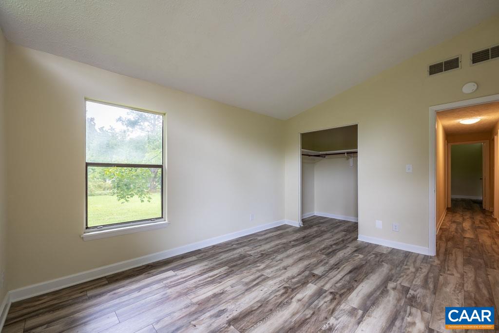 528 Matthew Mill Road Ruckersville, VA 22968 - Photo 16 of 27 a view of an empty room with wooden floor and a window
