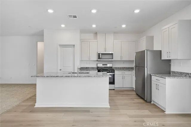a kitchen with appliances a sink and cabinets