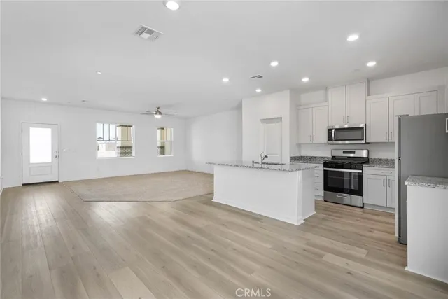 a large kitchen with stainless steel appliances granite countertop a large counter top a stove and a refrigerator