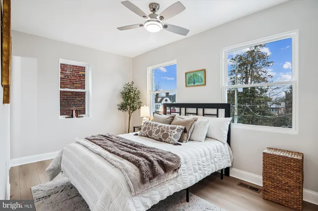 a bedroom with a bed and a dresser with wooden floor