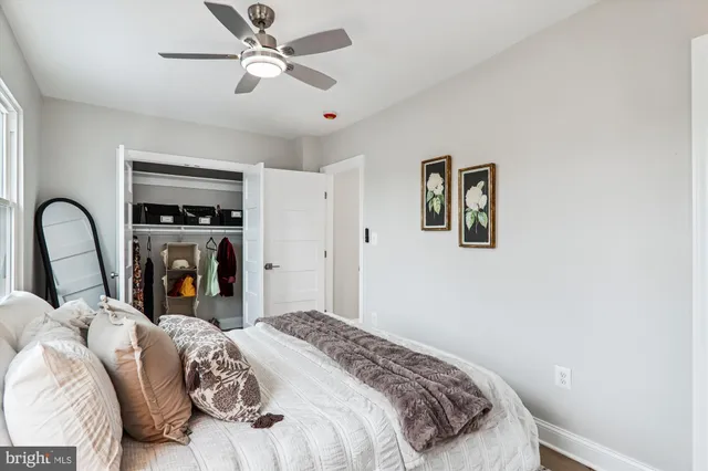 a bedroom with a bed next to a window and a flat screen tv