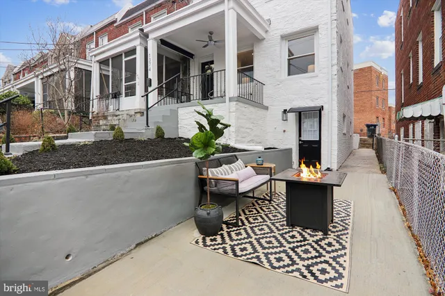 a view of a patio with couches table and chairs and potted plants