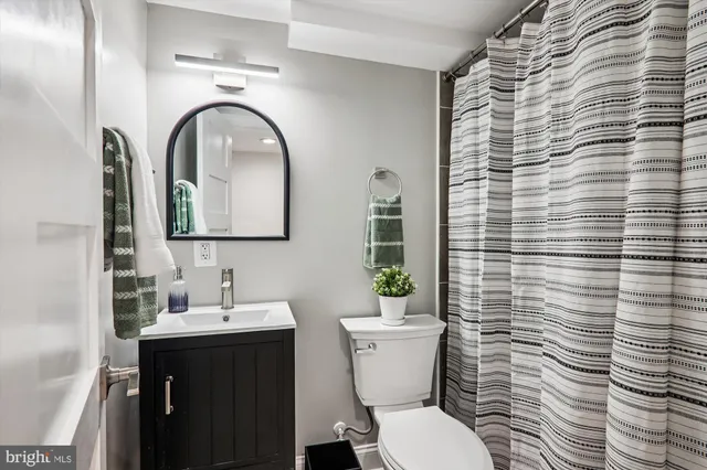 a bathroom with a toilet a sink and mirror