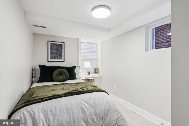 a bedroom with a bed and a painting on the wall