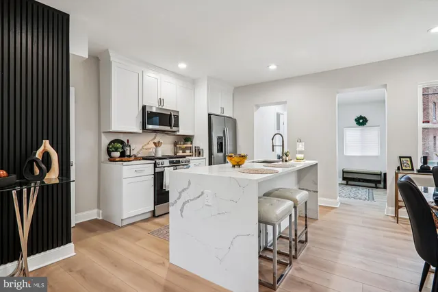 a kitchen with a refrigerator and a stove top oven