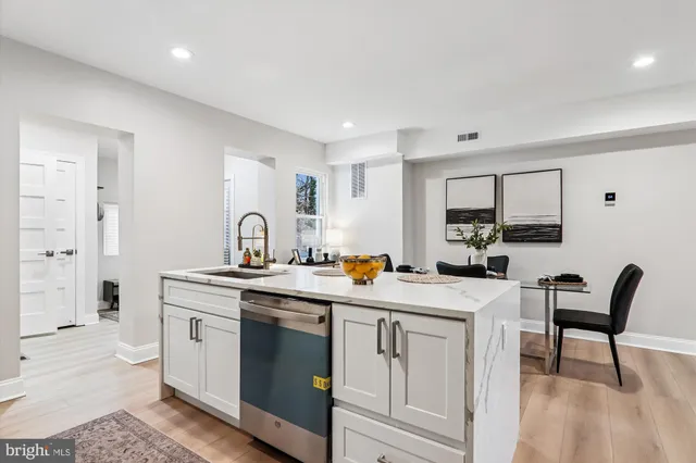 a view of a kitchen counter space with sink stainless steel appliances and cabinets