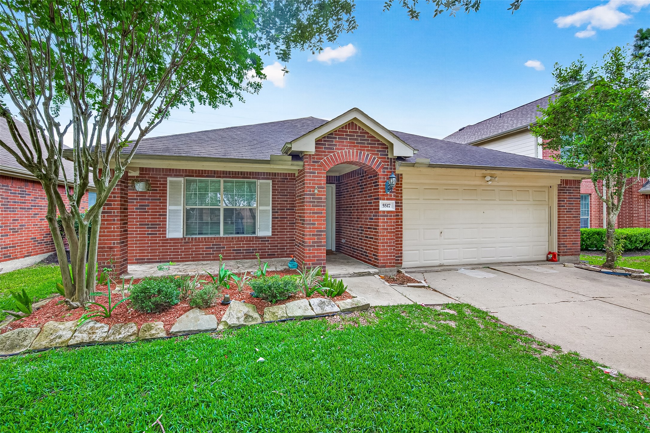 5517 Autumn Ash Lane Rosharon, TX 77583 - Photo 2 of 50 a front view of a house with a garden and plants