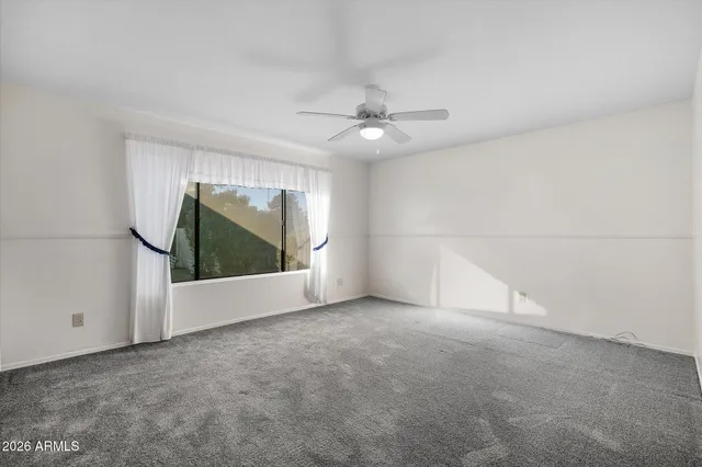 an empty room with a empty space and a ceiling fan