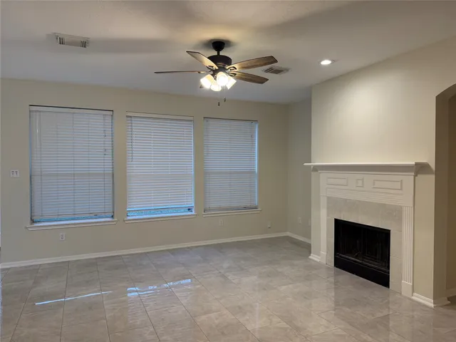 a view of an empty room with a fireplace and a window