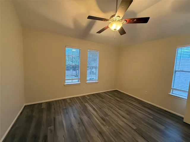 a view of empty room with wooden floor