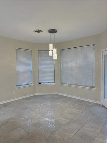 an empty room with windows and cabinet