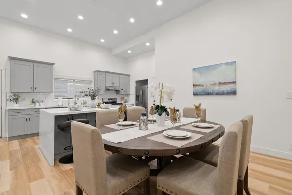 a view of a dining room and kitchen with furniture wooden floor and a rug
